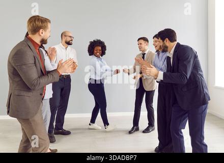 Firmenmitarbeiter feiern Erfolg und gratulieren weiblichen Kollegen im Haus. Stockfoto