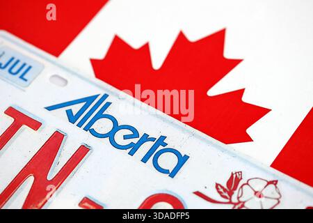 Alberta kanadisches Autokennzeichen auf der Flagge Kanadas Nahaufnahme. Führerschein- und Zulassungskonzept Stockfoto