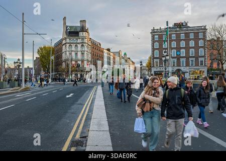 Weitwinkelblick auf die Straßen von Dublin von der O’Connell Bridge mit historischer Architektur, Fußgängern und Stadtströmungen. Stockfoto