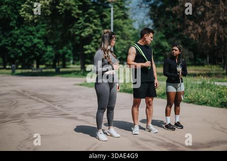 Gruppe von Freunden in aktiver Kleidung, die sich nach dem Fitness-Training im Freien ausruhen Stockfoto