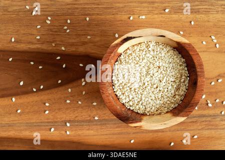 Winzige weiße Sesamsamen in kleiner Holzschale, Blick von oben Stockfoto