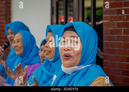Surabaya, Indonesien--2. März 2023 versammeln sich verschiedene Frauen, tragen passende blaue Hijabs und lächeln. Stockfoto