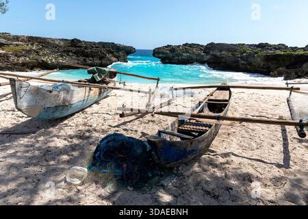 Wunderschöner Sandstrand auf sumba Insel in indonesien, weißer Sandstrand, türkisfarbenes Wasser, Klippen, Meeresbucht, traditionelle Holzboote zum Angeln Stockfoto