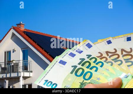 Mann, der Euro-Banknoten vor einem Sonnendach hält Stockfoto