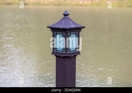 Nahaufnahme einer eleganten, traditionell chinesischen Säulenleuchte aus schwarzem Metall und Glas, geeignet für die dekorative Verwendung im Innenhof Stockfoto