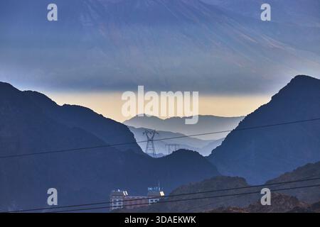 Mountain Silhouettes Power Lines and Industrial Structures in der Abenddämmerung in Nevada Stockfoto