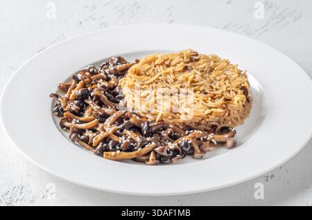 Das gemütliche Reisgericht besteht aus Butterpilzen, Sesamgarnitur und perfekt gekochtem Eigelb Stockfoto