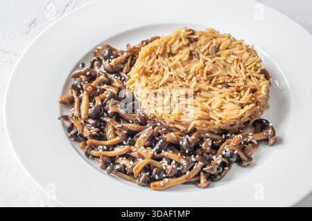 Das gemütliche Reisgericht besteht aus Butterpilzen, Sesamgarnitur und perfekt gekochtem Eigelb Stockfoto