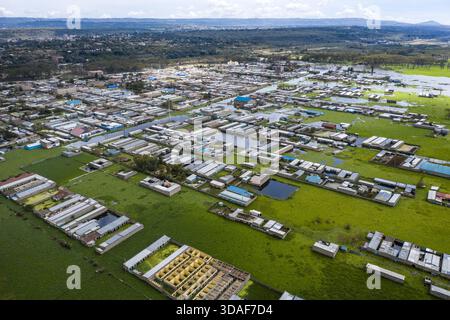 Aus der Vogelperspektive auf Häuser und Gebäude, die in der üppigen grünen Landschaft untergetaucht sind und den ruhigen Himmel über Naivasha, Nakuru, Kenia reflektieren. Stockfoto