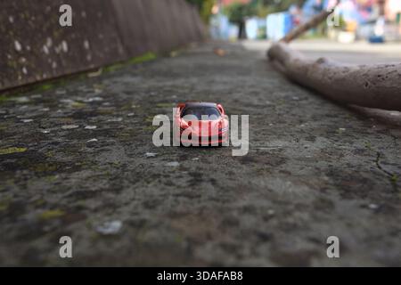 Cavi di Lavagna – 6. NOVEMBER 2025 – Hot Wheels Replik eines Ferrari SP90 Stradale auf einer Betonbank eines Platzes Stockfoto