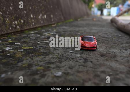 Cavi di Lavagna – 6. NOVEMBER 2025 – Hot Wheels Replik eines Ferrari SP90 Stradale auf einer Betonbank eines Platzes Stockfoto