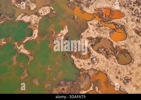 Aus der Vogelperspektive auf Boote, die an den Ufern des Flusses ruhen, im Kontrast zu den Erdtönen der umliegenden Landschaft, Tahirpur, Sylhet Divis Stockfoto