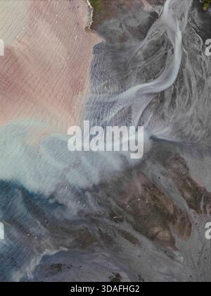 Luftaufnahme der Gletscherflüsse verflechten sich und malen eine abstrakte Leinwand aus milchigem Blau, sandigem Rosa und erdbraunem Braun über die Landschaft Alaskas, WHI Stockfoto