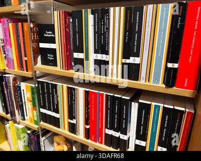 Manchester, Großbritannien - 15. November 2025: Reihen von bunten Buchrücken auf Holzregalen schaffen heute eine gemütliche, wissensreiche Bibliotheksszene. Stockfoto