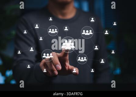 Soziales Netzwerk und menschliches Verbindungskonzept. Person berührt Gruppensymbole, symbolisiert Teamarbeit, Kommunikation, Zusammenarbeit, Menschen verbinden sich, Stockfoto