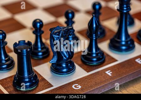 Nahaufnahme von schwarzen Schachfiguren auf einem Schachbrett, Stockfoto