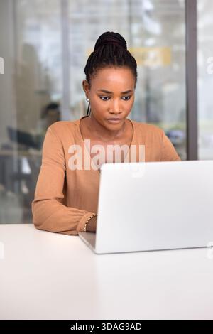 Fokussierte afroamerikanische Geschäftsfrau, die an einem Online-Projekt arbeitet Stockfoto