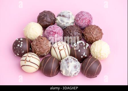 Verschiedene Arten von Schokoladentrüffeln sind auf Einer Oberfläche angeordnet. Stockfoto
