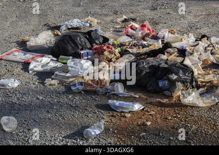 Recycelbare Gegenstände aus Kunststoff, Papier und Pappe, die auf dem Boden in einem öffentlichen Park in Quebec, Kanada, entsorgt werden Stockfoto