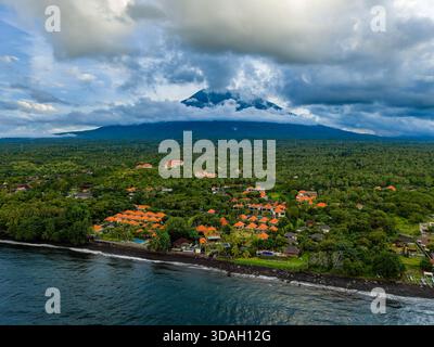 Malerischer Blick auf den Vulkan Mount Agung, der über dem üppigen tropischen Wald in Tulamben ragt Stockfoto