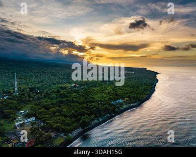 Dramatische Sonnenuntergangswolken über der Vulkanküste und dem Ozean in Tulamben, Bali Stockfoto