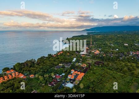 Blick aus einem hohen Winkel auf das Küstendorf, den Wald und das Meer in Bali, Indonesien Stockfoto