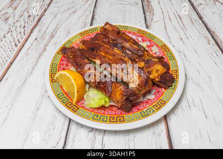 Langsam gekochte, knochenlose Rippchen im St. Louis-Stil, glasiert mit einer hausgemachten Honig-Senf-BBQ-Sauce, serviert auf Pergamentpapier Stockfoto