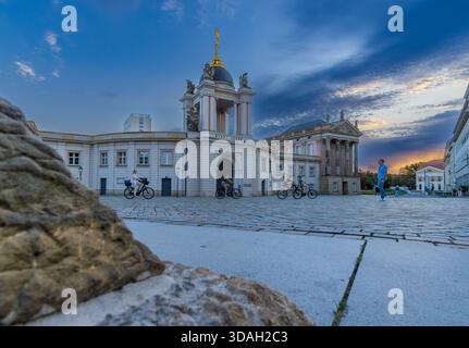 Der Alte Markt in Potsdam in der Abenddämmerung mit Touristen, die über den historischen platz spazieren und radeln. Stockfoto