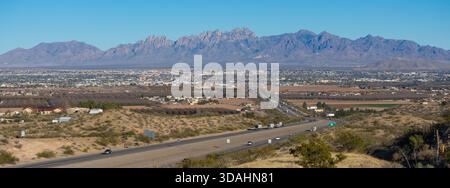 Las Cruces, New Mexico, USA City Skyline neben den Organ Mountains, von der Wüste aus gesehen, neben einer Autobahn, die in die Stadt führt Stockfoto