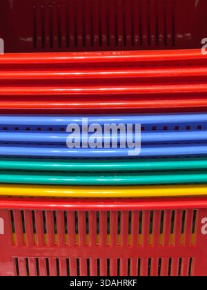 Lebendiger abstrakter Hintergrund farbenfroher Kunststoffröhren. Sich wiederholende vertikale Linien in Rot, Blau, Grün und Gelb erzeugen ein fröhliches und geordnetes Muster. S Stockfoto