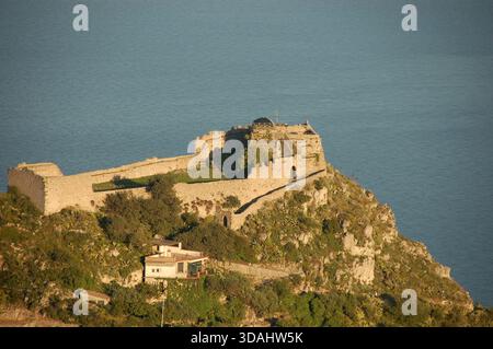 Antike Steinfestung auf einer felsigen Klippe über dem Meer in Sizilien, mit dramatischem Blick auf die Küste und mit historischen Gebäuden aus dem Mittelmeerraum Stockfoto