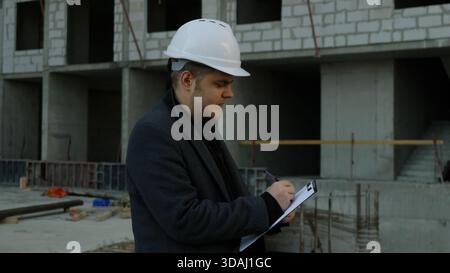 Zwei Bauexperten diskutieren Pläne auf einer Baustelle Stockfoto