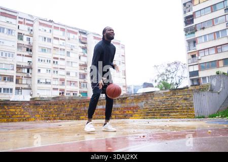 Junger Afrikanischer Mann, Der Draußen Basketball Dribbelt. Stockfoto