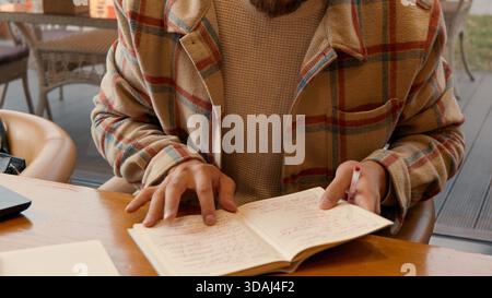 Nahaufnahme eines Mannes, der aufmerksam zuhört, während er sich über einen Tisch lehnt Stockfoto