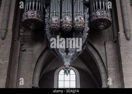 TRIER, DEUTSCHLAND - 20. April 2025: Die große Pfeifenorgel im Trierer Dom zeigt kunstvoll verzierte Blumenschnitzereien und eine dramatische Hängestruktur, die sich über Stein erhebt Stockfoto