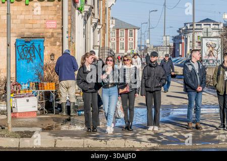 Junge Menschen gehen an einem informellen Straßenstand auf dem Fußweg von Petrosawodsk vorbei und stehen im Kontrast zu Jugendstil und prekärer städtischer Wirtschaft in Karelien. Stockfoto