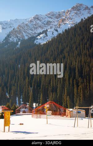 Holzrahmen aus Jurten auf einer verschneiten Lichtung in einem Öko-Camp, umgeben von einem Kiefernwald Stockfoto