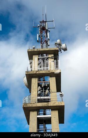 Telekommunikationsturm mit Antennen und Satellitenschüsseln gegen den Himmel. Moderne Infrastruktur für Mobilfunk-, Internet-, Radio- und TV-Signalübertragung Stockfoto