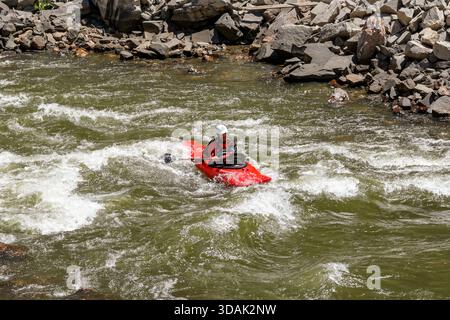 Canyon City, Colorado, USA - 22. Mai 2025: Menschen in Kajaks paddeln auf Stromschnellen auf dem Arkansas River, der durch die Royal Gorge fließt. Stockfoto