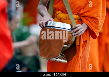 Abschluss der buddhistischen Novizen, die am frühen Morgen ihre Almosenschalen für Almosen tragen. Luang Prabang. Luang Prabang. Laos. Stockfoto