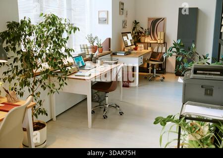 Moderner Bürobereich mit Schreibtischen mit Computern und Innenanlagen Stockfoto