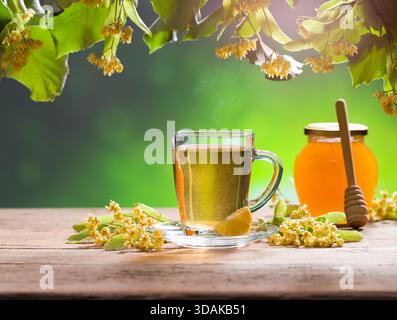 Ein Glas Lindentee. Lindenblumen und Honig im Hintergrund Stockfoto