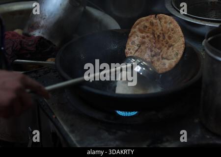 Verschiedene Arten von Paranthas, ein indisches Kuschelbrot, werden in einem Restaurant im Paranthe Wali Gali in Alt-Delhi, Chandni Chowk, frittiert. Stockfoto
