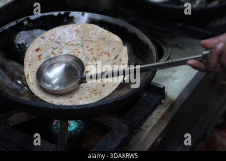 Verschiedene Arten von Paranthas, ein indisches Kuschelbrot, werden in einem Restaurant im Paranthe Wali Gali in Alt-Delhi, Chandni Chowk, frittiert. Stockfoto