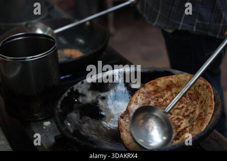 Verschiedene Arten von Paranthas, ein indisches Kuschelbrot, werden in einem Restaurant im Paranthe Wali Gali in Alt-Delhi, Chandni Chowk, frittiert. Stockfoto
