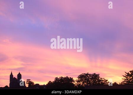 Kirche auf dem Hügel unter violettem und orangenem Abendhimmel (Breisach, Baden, Deutschland) Stockfoto