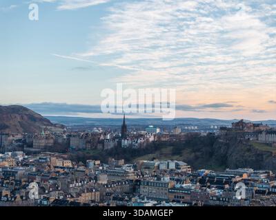 Blick aus der Vogelperspektive auf das historische Edinburgh Castle, das sich auf dem Castle Rock thront, mit dem berühmten Stadtbild, das sich in Richtung Arthurs Sitz unter einer weichen Wolke erstreckt Stockfoto