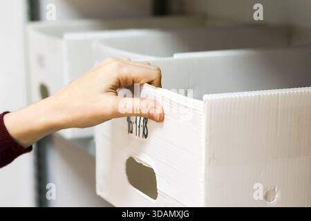 Ziehen Sie die Kante des weiß gekennzeichneten Behälters am Metallgestell Stockfoto