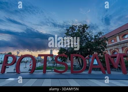Großes rotes „POTSDAM“-Stadtschild bei Sonnenuntergang, in der Nähe des Filmmuseums Potsdam und in der Nähe des Alten Marktes im historischen Stadtzentrum. Stockfoto