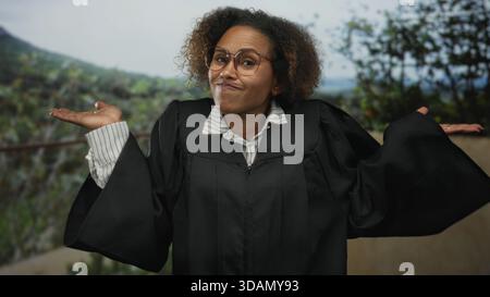 Eine Richterin im Gewand mit Brille hebt die Hand und berührt die Haare auf der Terrasse des Gebäudes im Freien; Skepsis ist weinend. Stockfoto